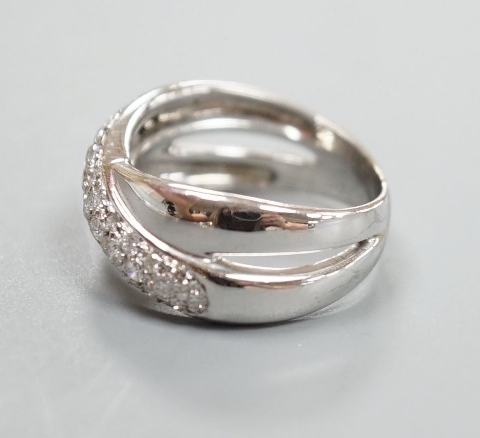 A modern 750 white metal and pave set set diamond crossover ring, size L/M, gross weight 5.9 grams.